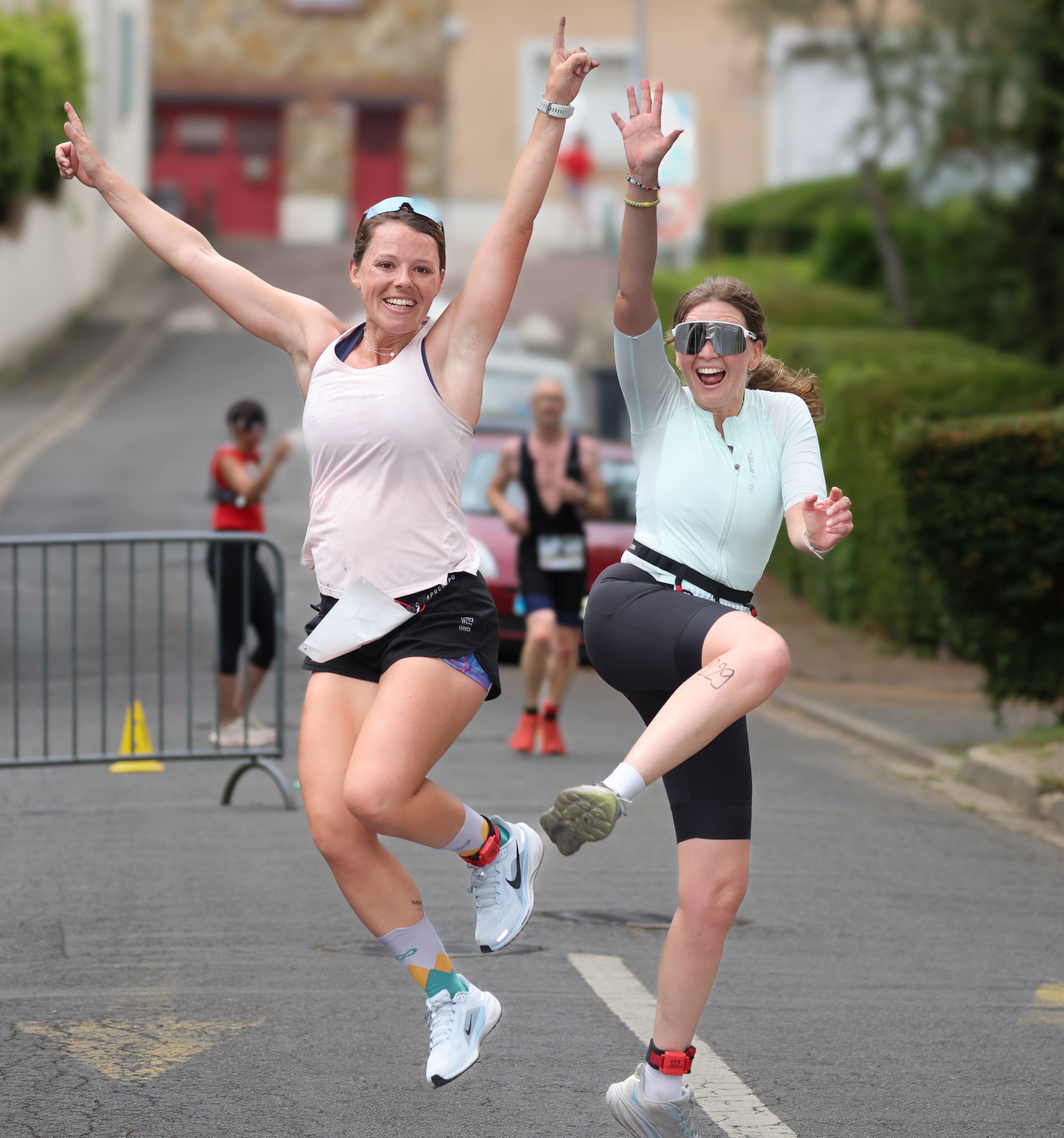 Deux participantes sautent de joie sur le parcours de course à pied